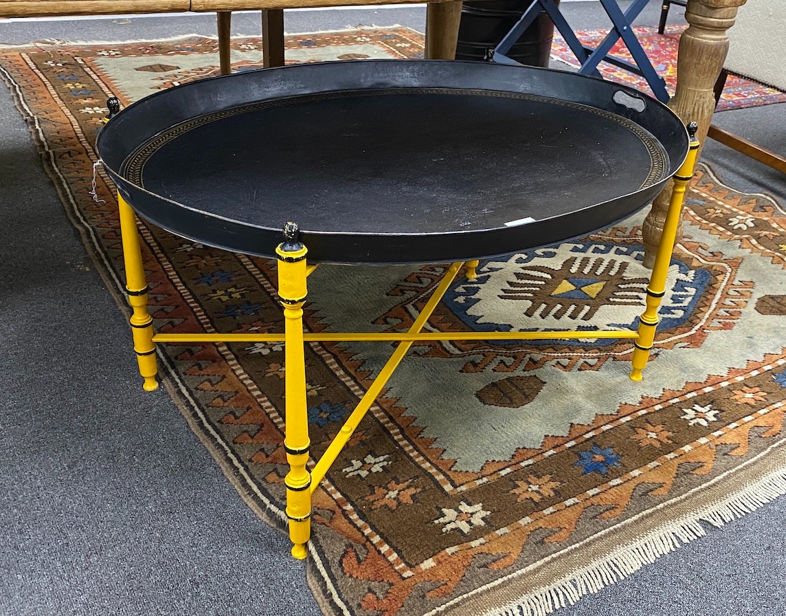 An oval Regency style black japanned tin tray on folding stand, tray width 80cm, depth 61cm, height 45cm